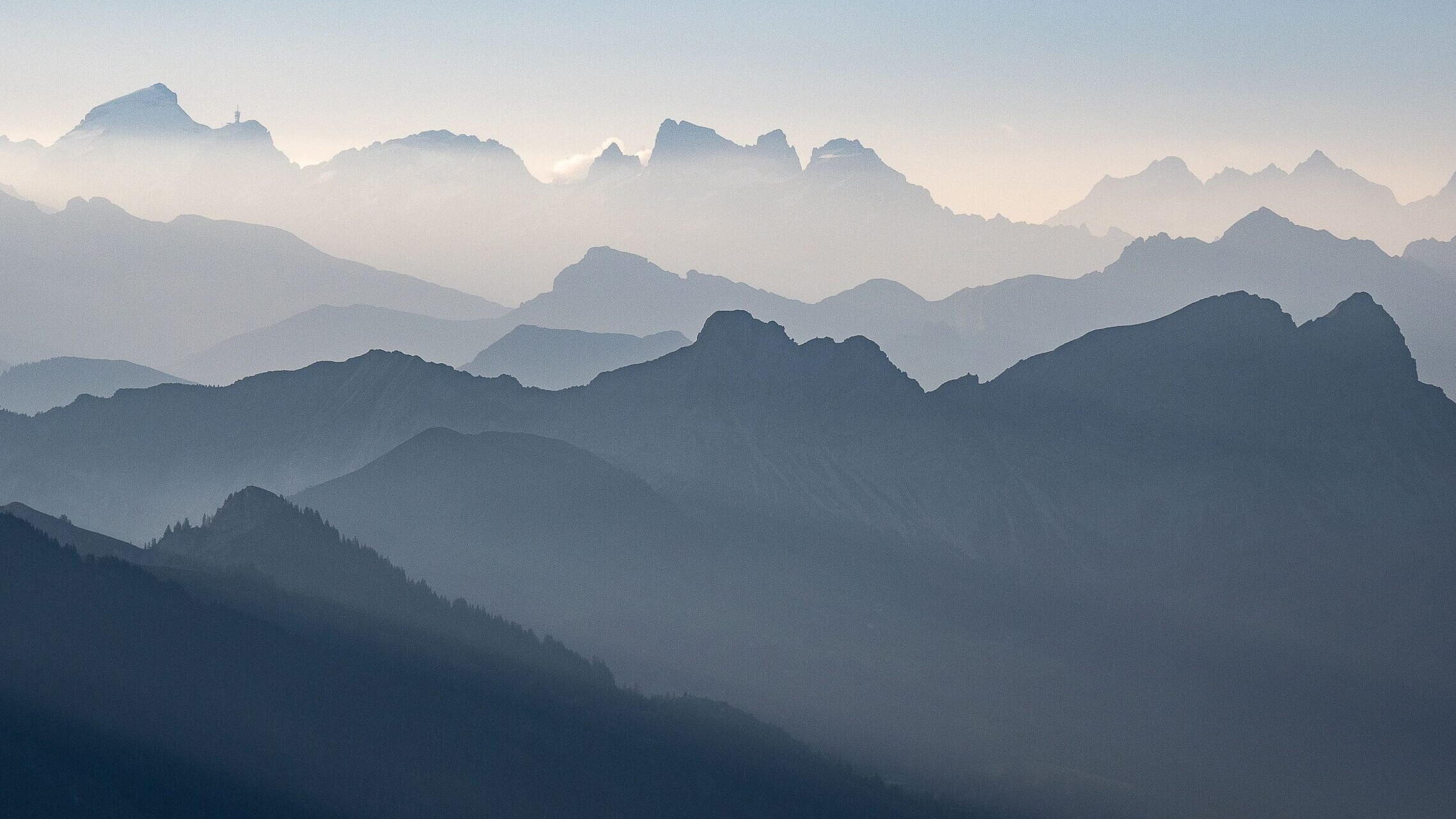 Silhouette der Gebirgsketten von Voralpen und Alpen in Blautönen
